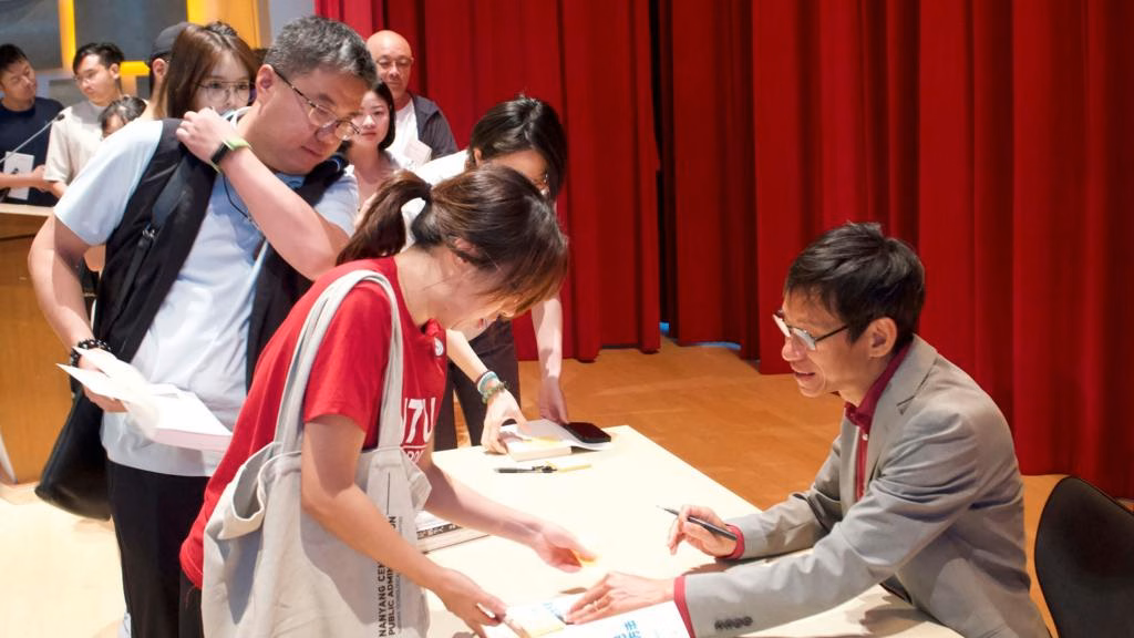 Biao Xiang giving his autograph.